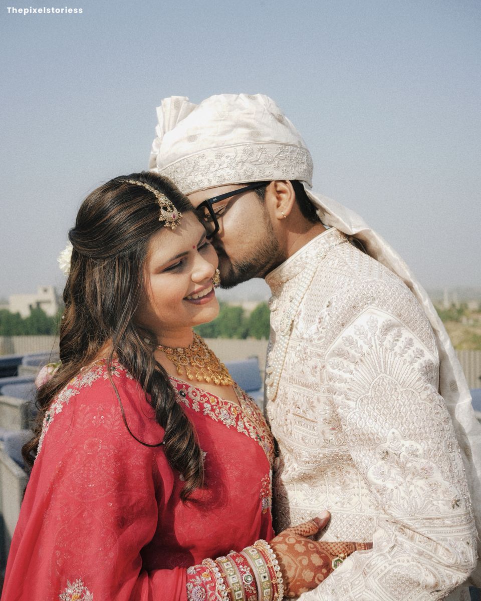 Groom kissing the bride's forehead as she laughs
